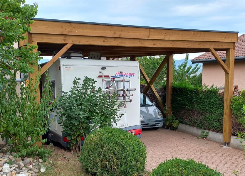 carport abritant un camping car et une voiture